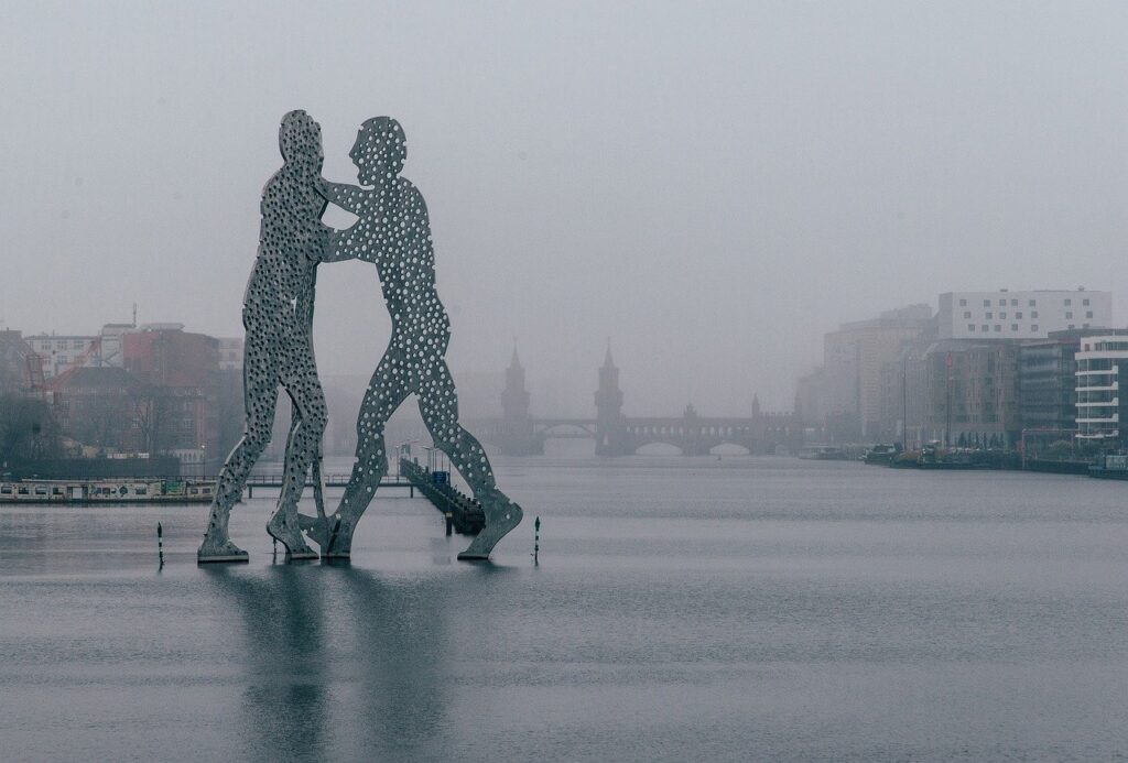 Ville dans le brouillard avec une statue - Une Autre Voix Ville dans le brouillard avec une statue de deux hommes qui se battent