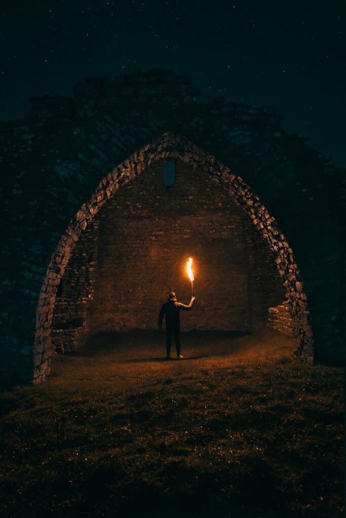 Frontières entre réalité et fantasme - Une Autre Voix Un homme tient une torche dans un endroit sombre