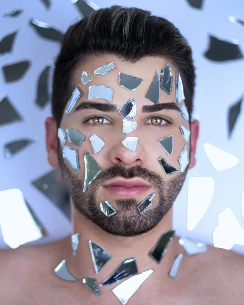 Miroir brisé de la narration non fiable - Une Autre Voix Un homme a des morceaux de miroir sur son visage